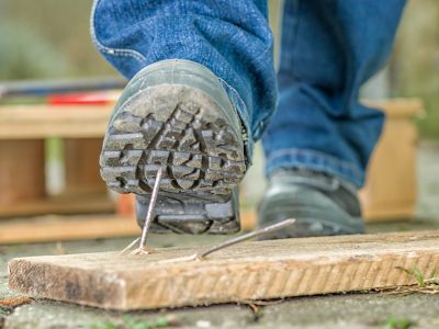 Worker with safety boots steps on a nail